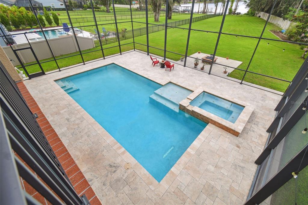 An elevated view of a screened-in swimming pool and spa with a large backyard — 2566 LAKE MANOR DRIVE, LAND O LAKES, FL