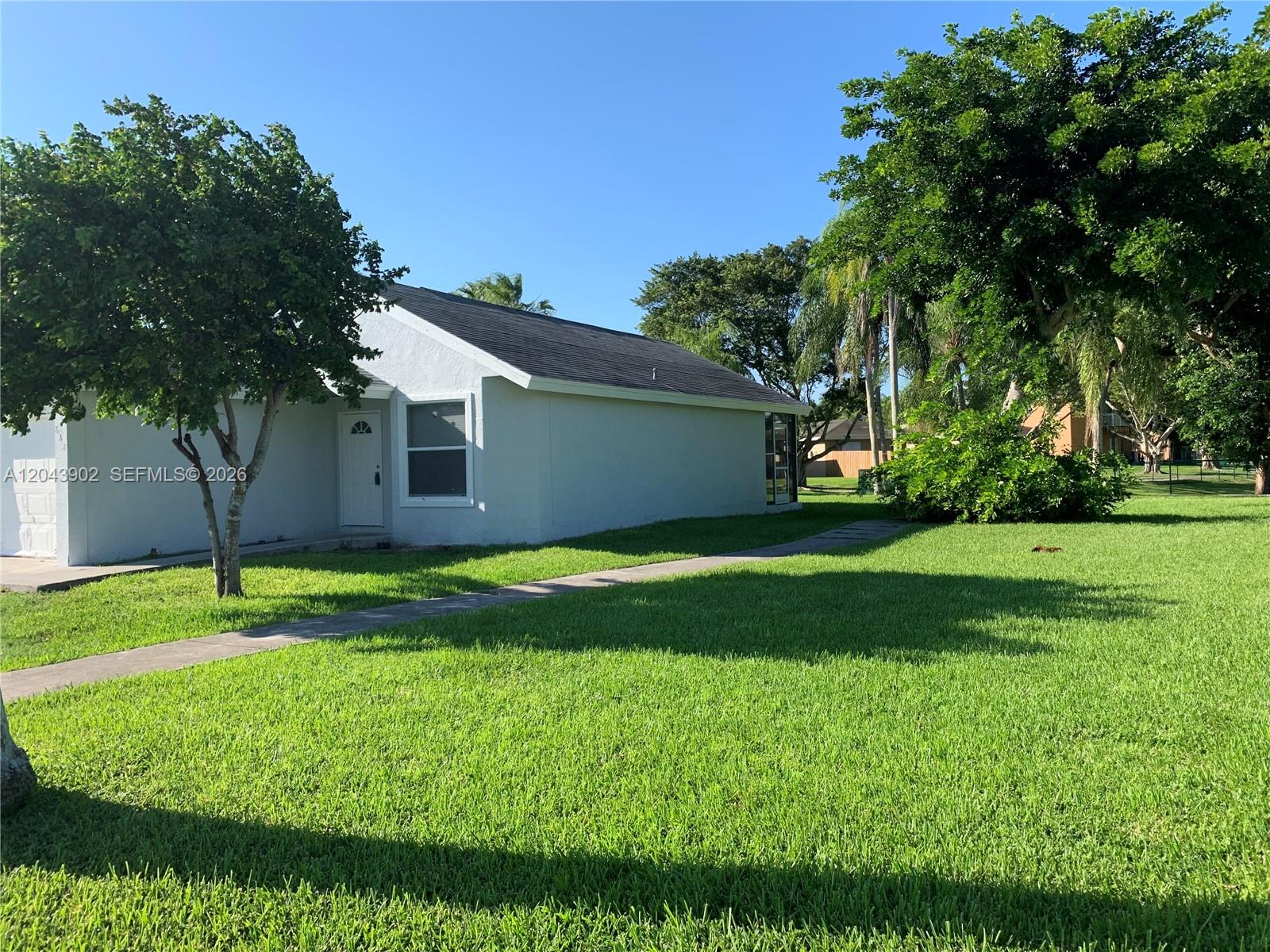 A single-story white house with a dark roof sits on a large grassy lawn — 848 SW 10th St, Florida City FL 33034, FLORIDA CITY, FL
