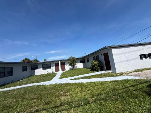 A low-rise apartment building with a gray exterior, red doors, and a paved walkway — 2840 Avenue S, West Palm Beach FL 33404, WEST PALM BEACH, FL