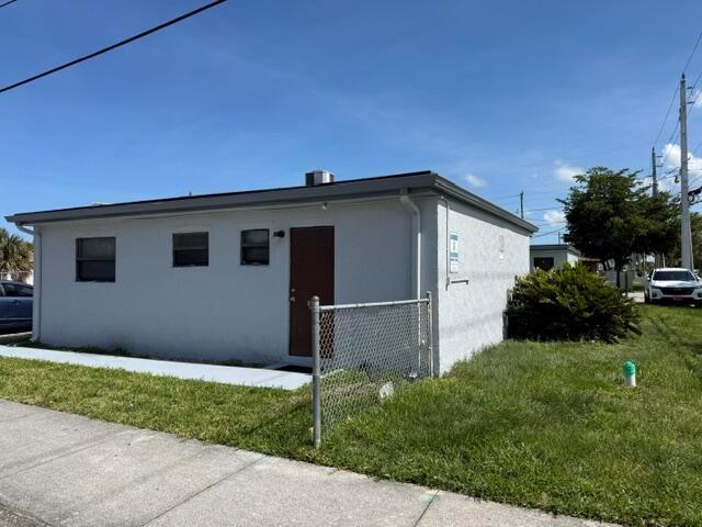 A single-story, light-colored stucco building with a brown door and a chain-link fence — 2840 Avenue S, West Palm Beach FL 33404, WEST PALM BEACH, FL