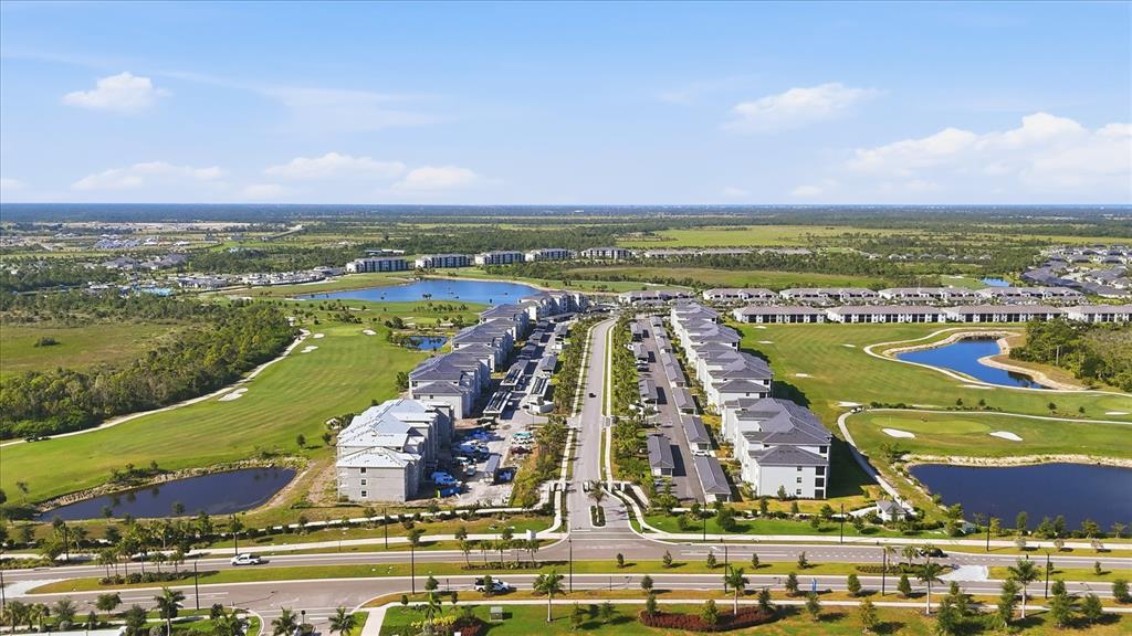Aerial view of a multi-family residential complex surrounded by a golf course and ponds — 17655 OPAL SAND DRIVE UNIT 107, VENICE, FL