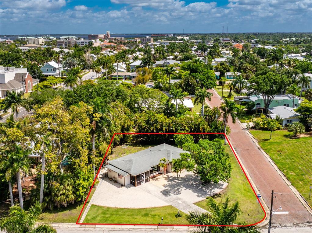 An aerial view shows a single-story house with a screened porch on a corner lot — 312 MCGREGOR STREET, PUNTA GORDA, FL