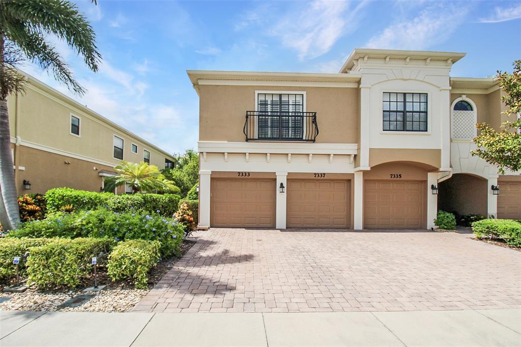 A two-story tan building features three garage doors and a paved driveway — 7333 SKYBIRD ROAD, BRADENTON, FL