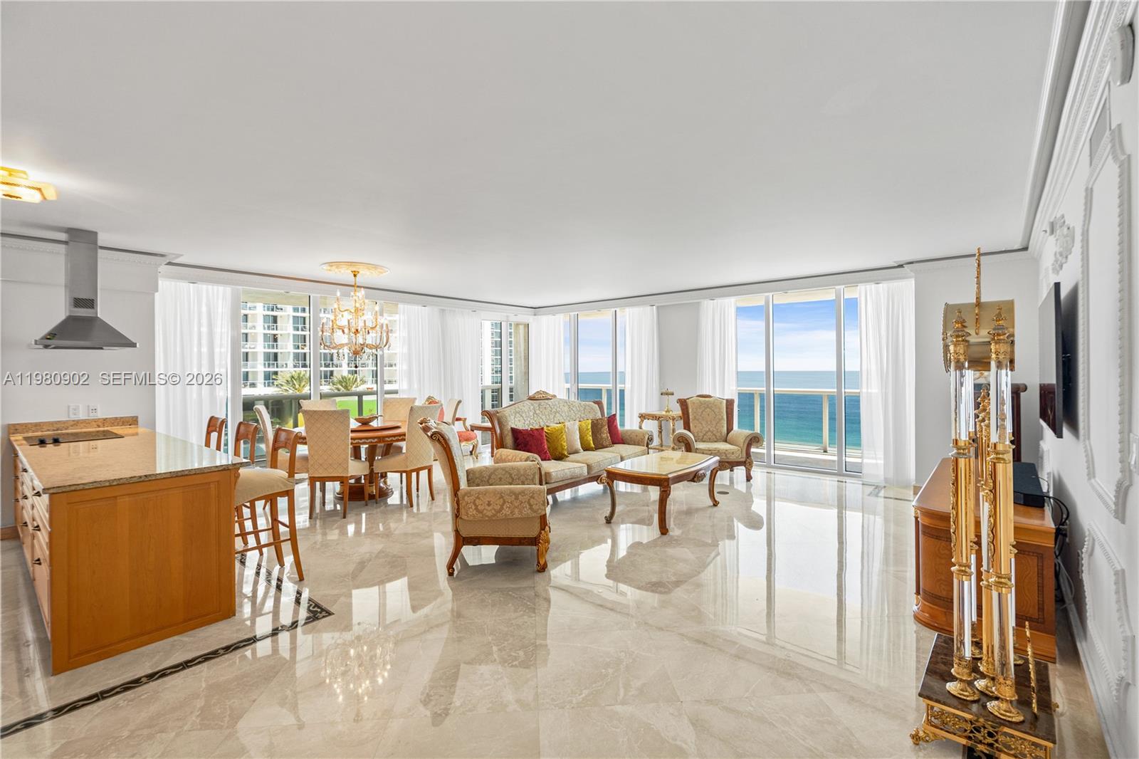 A bright open-concept living and dining area features marble floors, ocean views, and wood cabinetry — 1800 S Ocean Dr # 1601, Hallandale Beach FL 33009, HALLANDALE BEACH, FL