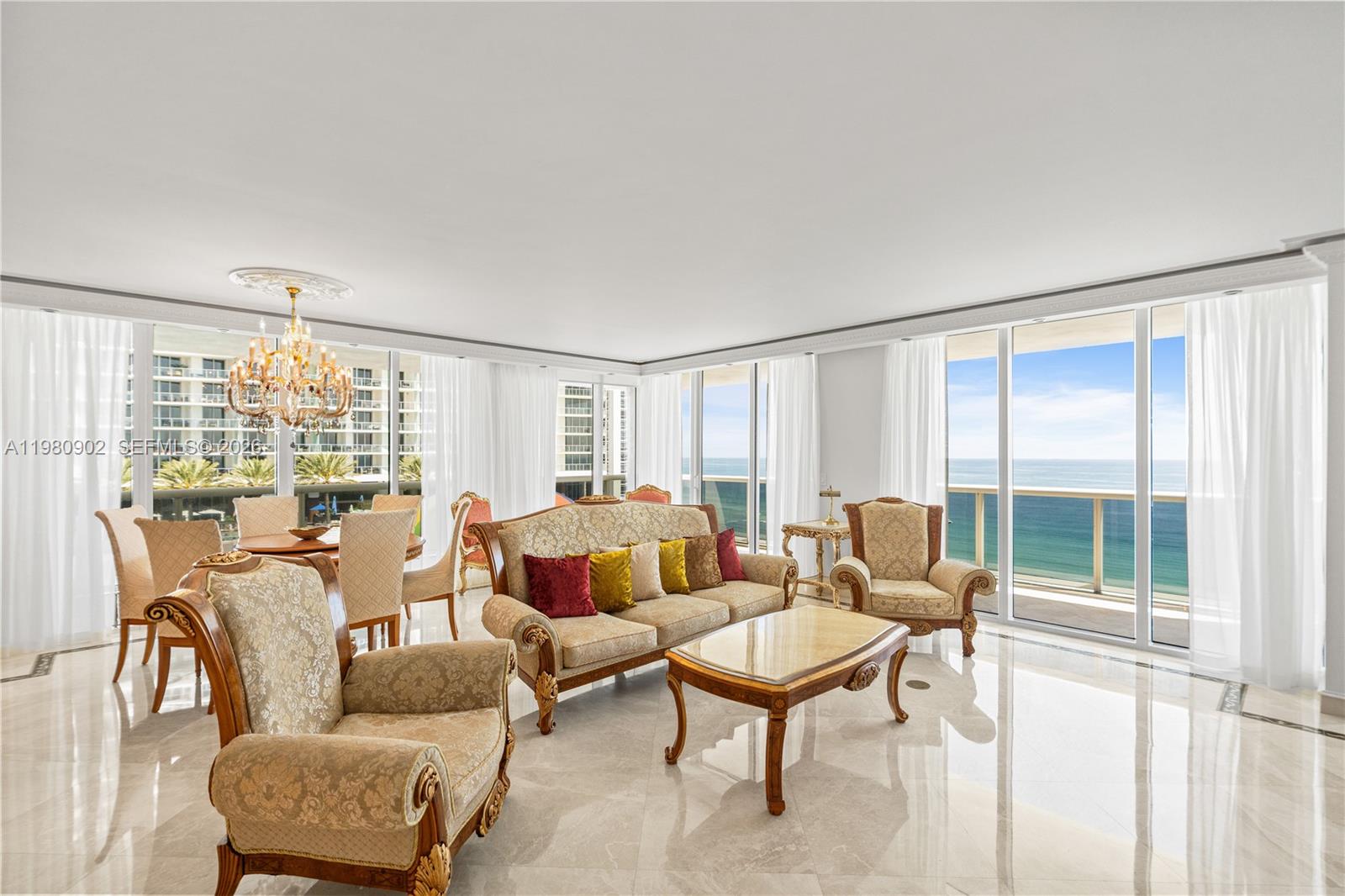 A bright living and dining room features marble floors, ornate furniture, and ocean views — 1800 S Ocean Dr # 1601, Hallandale Beach FL 33009, HALLANDALE BEACH, FL