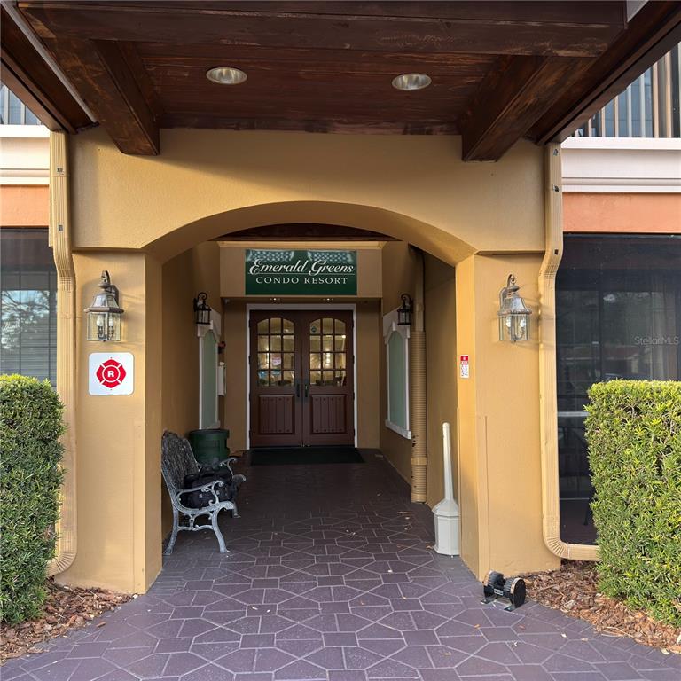 The entrance to the Emerald Greens Condo Resort features a covered walkway and double doors — 13941 CLUBHOUSE DRIVE UNIT 208, TAMPA, FL