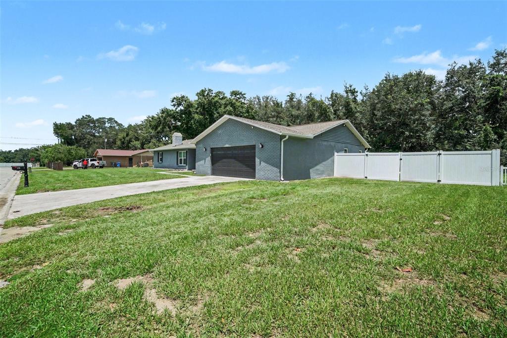 A gray brick house with a two-car garage and a white vinyl fence — 206 JACOB RYAN COURT, BRANDON, FL