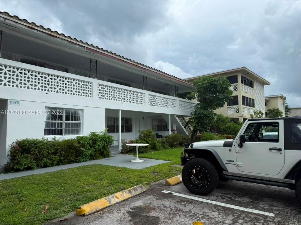 A white two-story apartment building with a decorative balcony railing and a parked Jeep — 11970 NE 19th Dr, North Miami FL 33181, NORTH MIAMI, FL