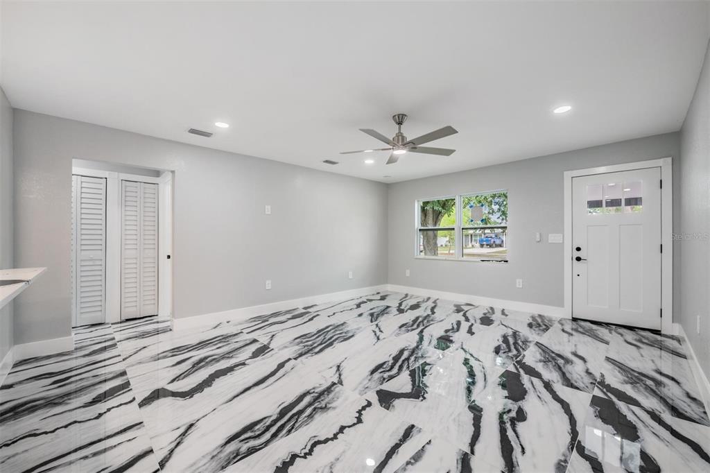 A room with light gray walls, a ceiling fan, and high-contrast black and white flooring — 134 EMERALD LANE, LARGO, FL