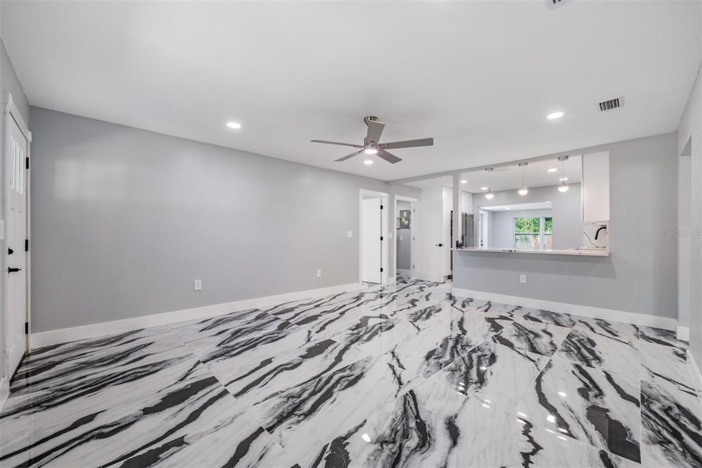 A living room with gray walls and high-contrast black and white marble-patterned tile flooring — 134 EMERALD LANE, LARGO, FL