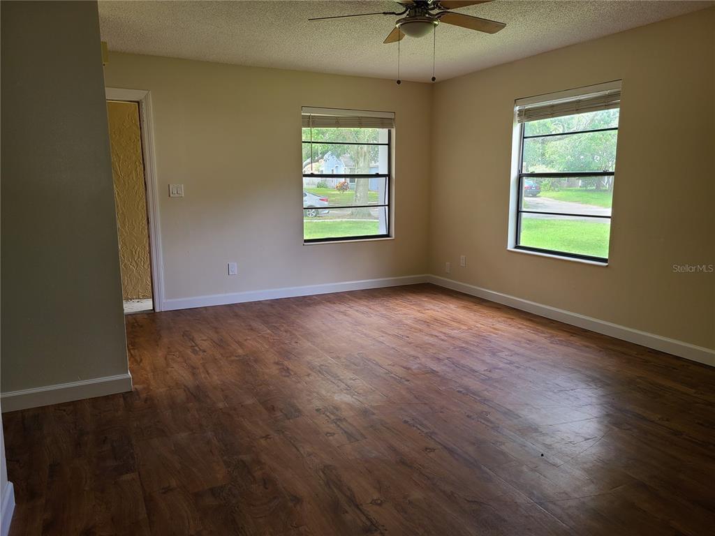 An empty room with wood-look flooring, two windows, and a ceiling fan — 5427 PEACO PLACE, WINTER PARK, FL