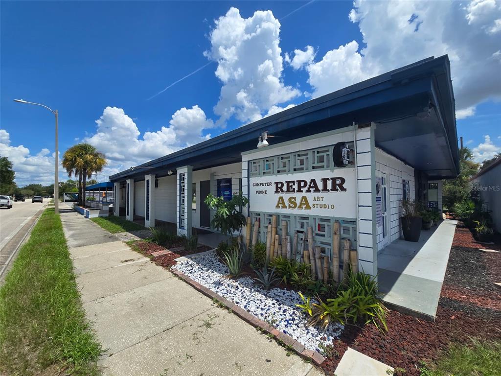 A single-story commercial building with a white facade, bamboo accents, and a blue roof — 741 BENNETT ROAD, ORLANDO, FL