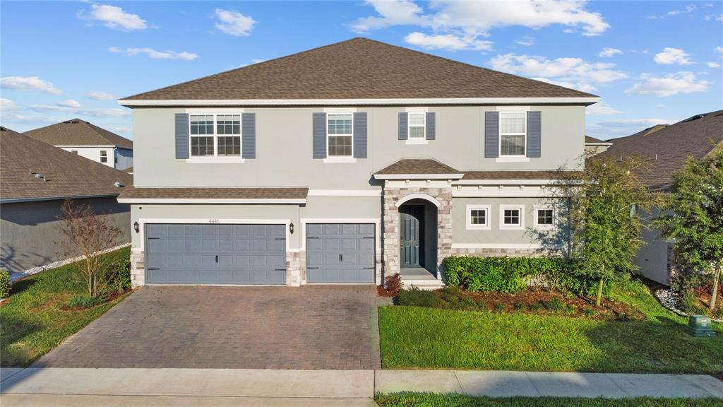 A bright entryway with light wood-look tile flooring leads to a staircase and living area — 4446 RENLY LANE, CLERMONT, FL