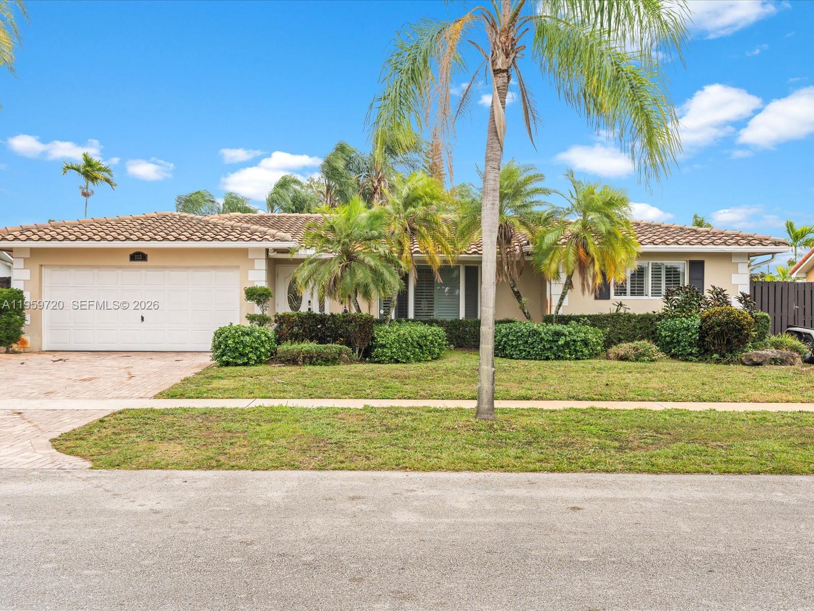A single-story house with a tiled roof, a two-car garage, and palm trees in front — 1113 N 46th Ter, Hollywood FL 33021, HOLLYWOOD, FL
