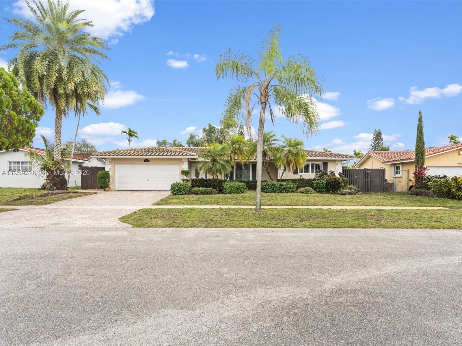 A single-story house with a white garage, palm trees, and a landscaped front yard — 1113 N 46th Ter, Hollywood FL 33021, HOLLYWOOD, FL
