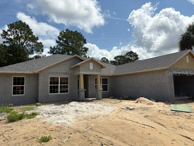 A single-story house under construction features a gray stucco exterior and a shingled roof — 17833 SW 61ST LANE ROAD, DUNNELLON, FL