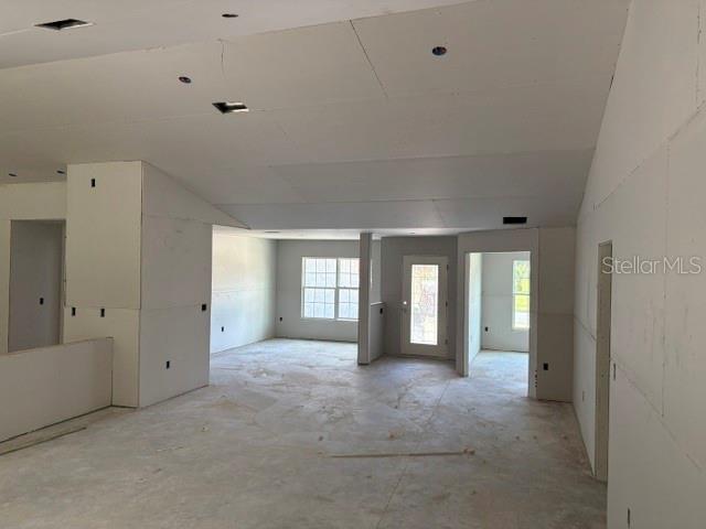 An unfinished interior room features drywall walls and ceilings with recessed lighting and window views — 17833 SW 61ST LANE ROAD, DUNNELLON, FL