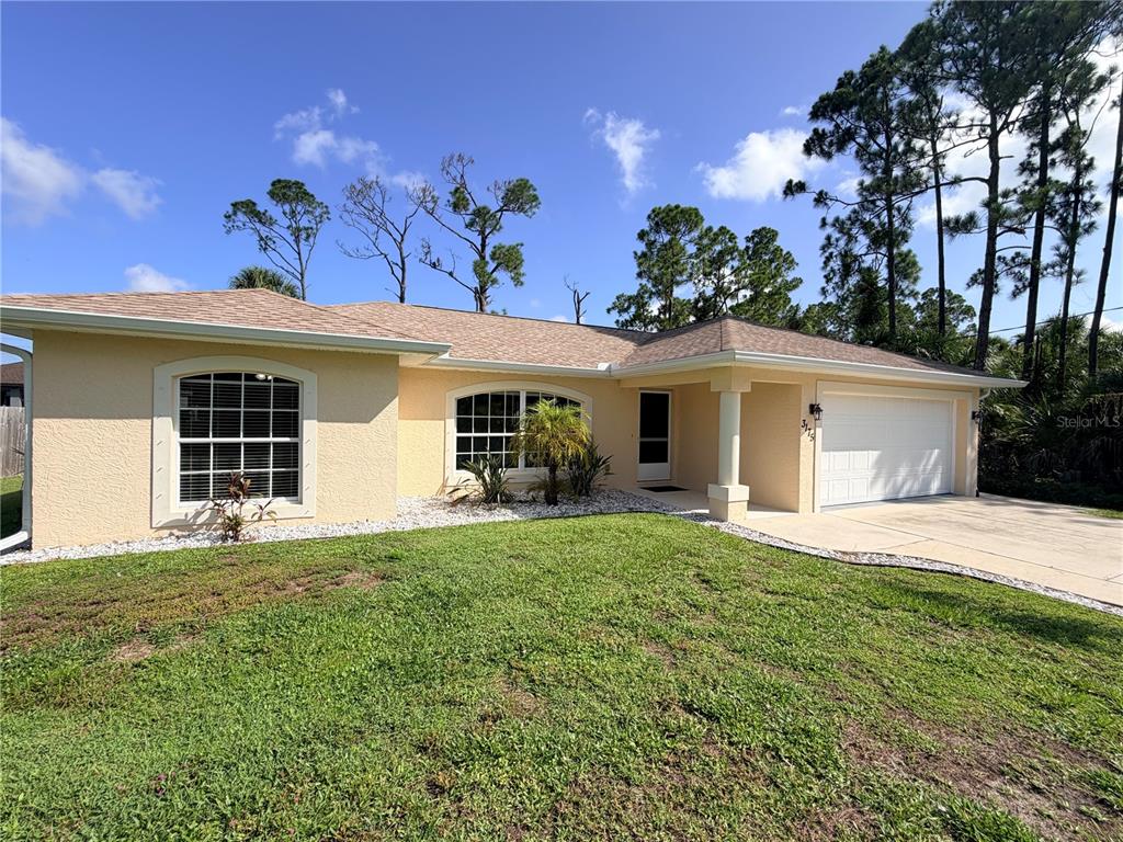 A single-story house with a yellow stucco exterior, a shingled roof, and a two-car garage — 3175 WENTWORTH STREET, NORTH PORT, FL