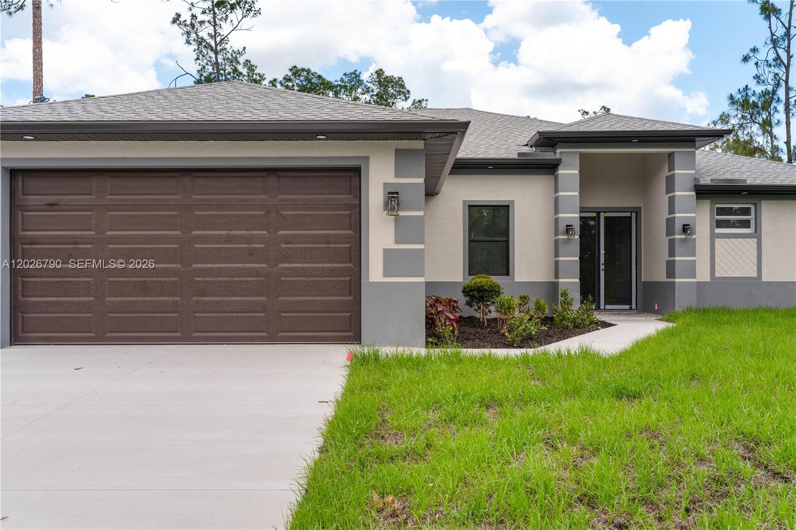 The exterior of a single-story house features a brown garage door and gray accents — 1116 leroy ave, Lehigh Acres FL 33972, LEHIGH ACRES, FL