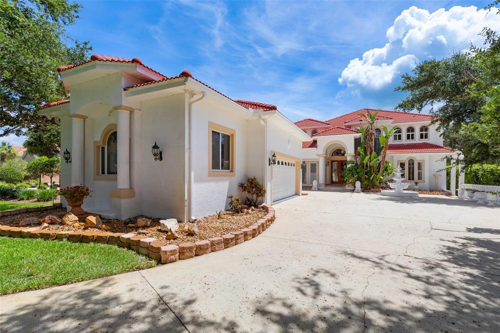 A large white house with a red tile roof and a circular concrete driveway — 63 FRONT STREET, PALM COAST, FL