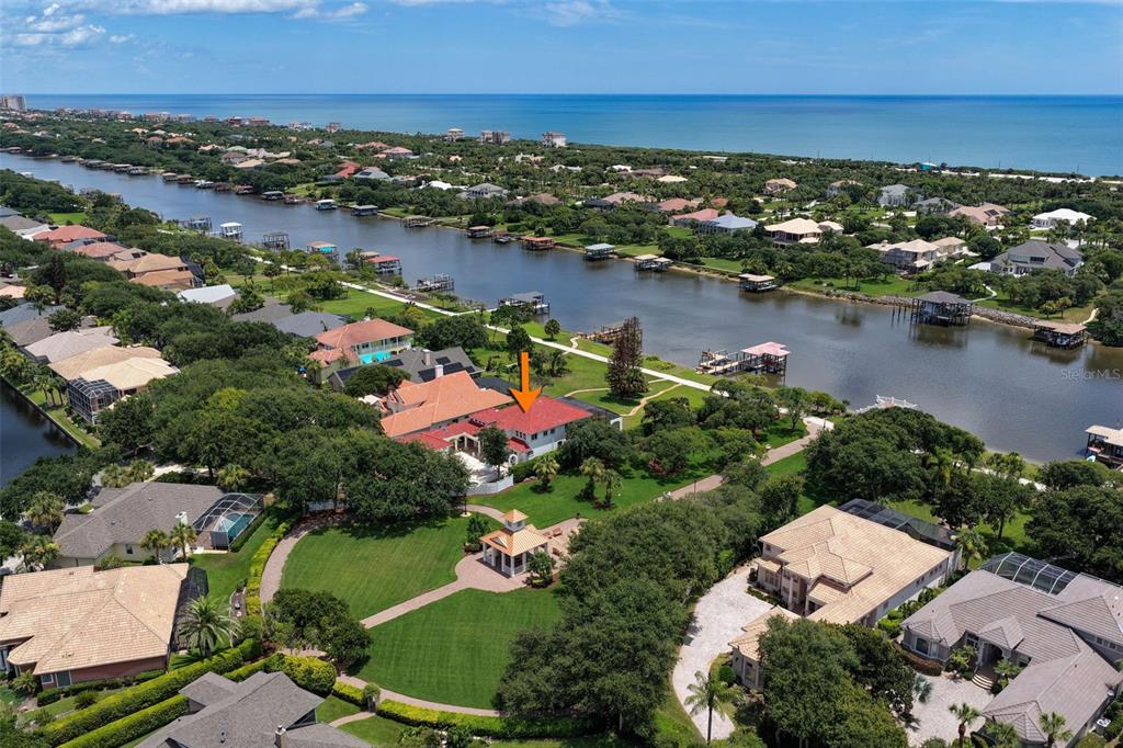An aerial view shows a large waterfront home with a red roof and gazebo — 63 FRONT STREET, PALM COAST, FL