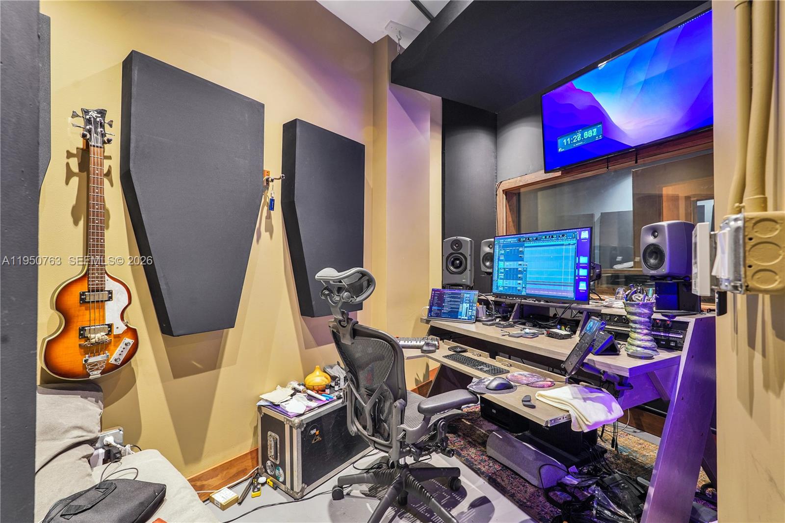 A home recording studio features acoustic wall panels, a desk with computer equipment, and a bass — 1260 NW 29th St, Miami FL 33142, MIAMI, FL