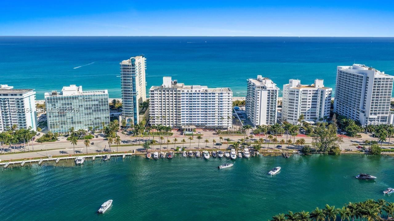 An aerial view of several high-rise apartment buildings situated between a waterway and the ocean — 5005 Collins Ave # 504, Miami Beach FL 33140, MIAMI BEACH, FL