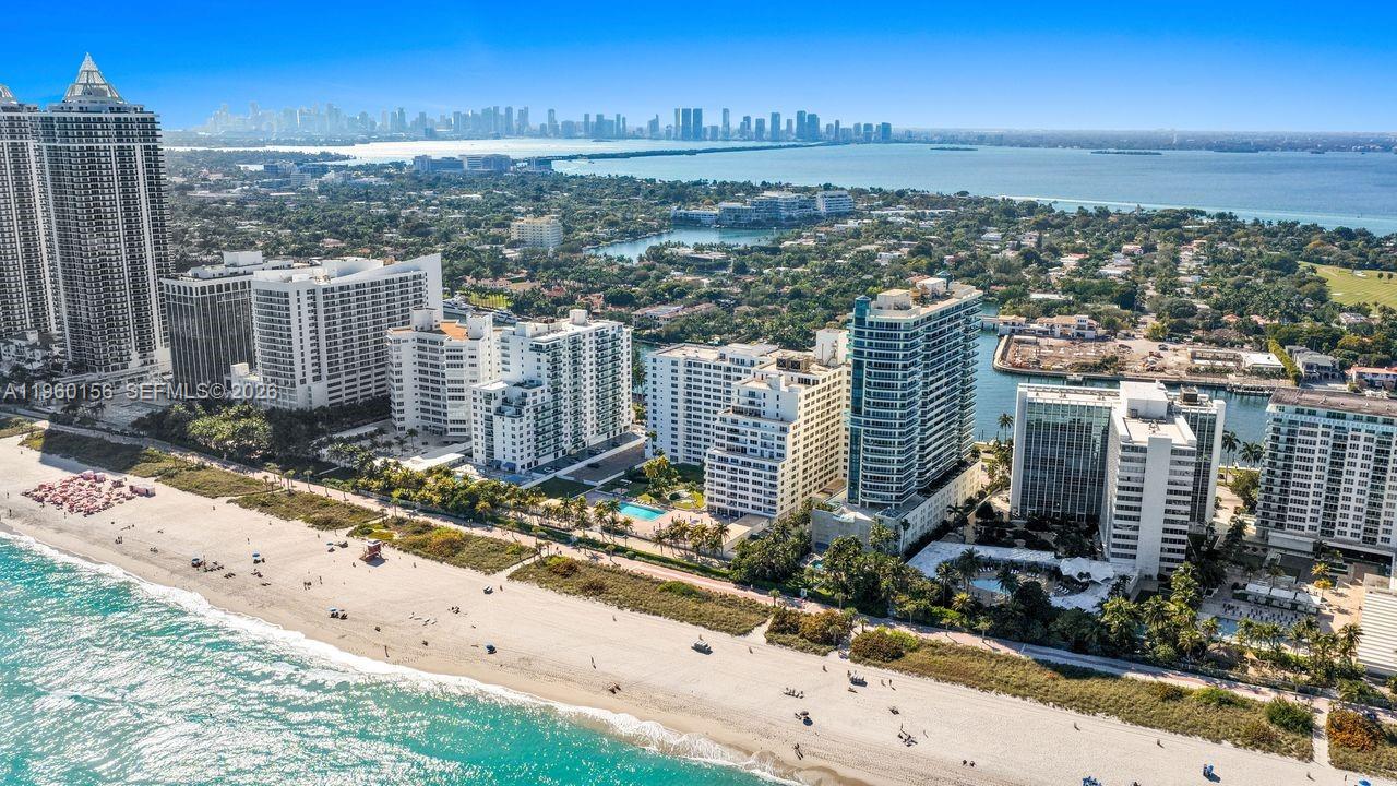 An aerial view of a sandy beach lined with several high-rise residential buildings and trees — 5005 Collins Ave # 504, Miami Beach FL 33140, MIAMI BEACH, FL