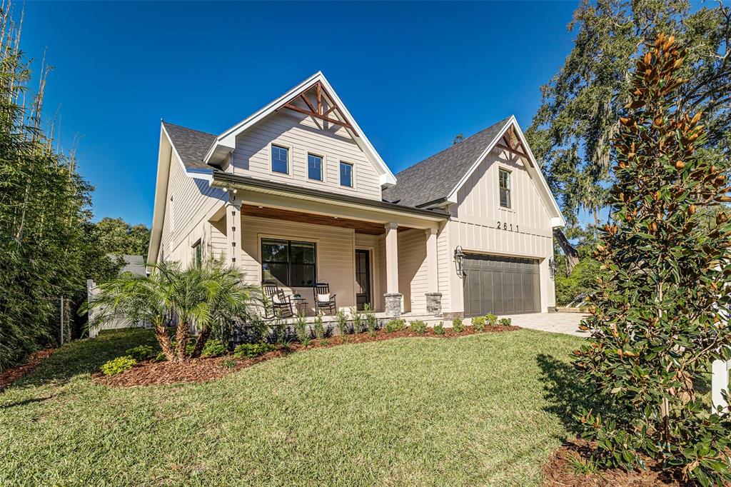 A two-story house with light siding, a front porch, and an attached two-car garage — 2611 BERKELEY AVENUE, LAKELAND, FL