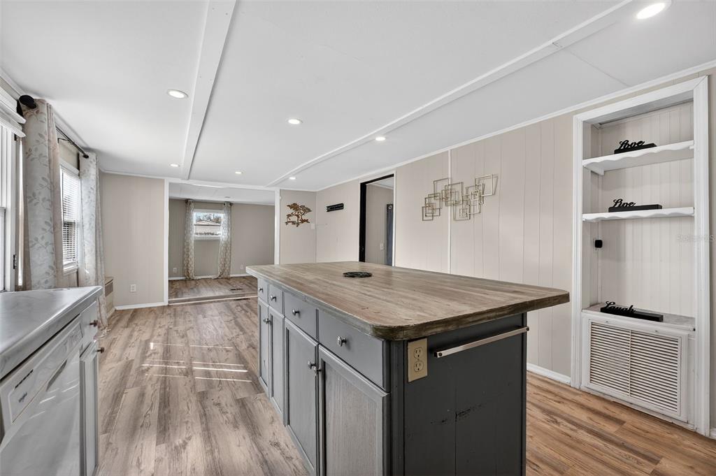 A kitchen island with a wood countertop sits in a room with light-colored walls — 5413 ISABELLE AVENUE, PORT ORANGE, FL
