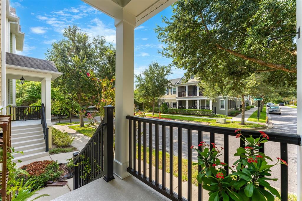 A view from a covered front porch looking out toward a residential street and trees — 1380 MILL STREAM LANE, WINTER SPRINGS, FL