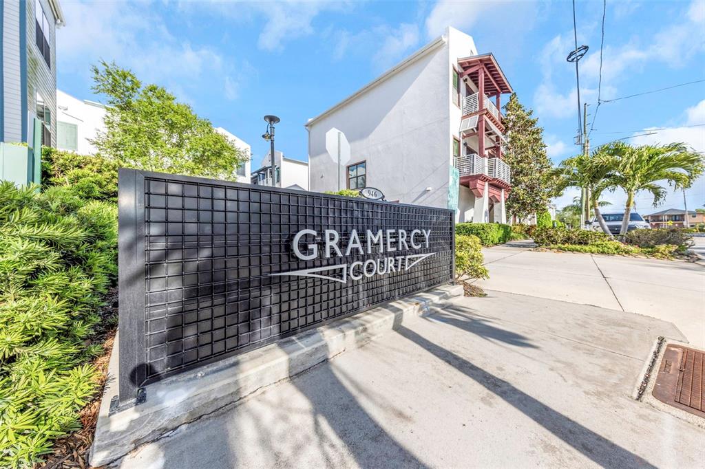A metal sign for Gramercy Court stands in front of a multi-story residential building — 946 HIGHLAND AVENUE UNIT 45, DUNEDIN, FL