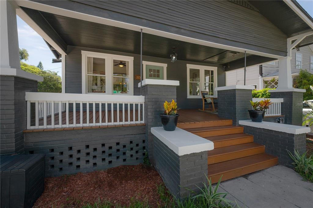 A gray house with a covered front porch, wooden steps, and white railings — 2831 N MORGAN STREET, TAMPA, FL