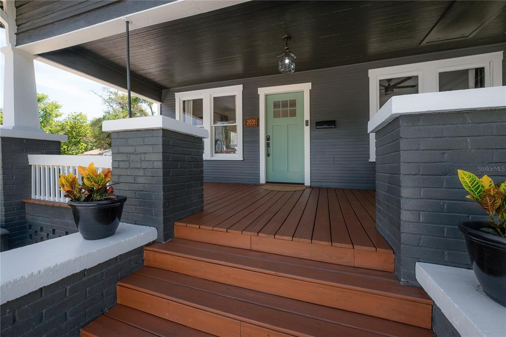 A front porch with wooden steps, a light green door, and dark gray brick pillars — 2831 N MORGAN STREET, TAMPA, FL