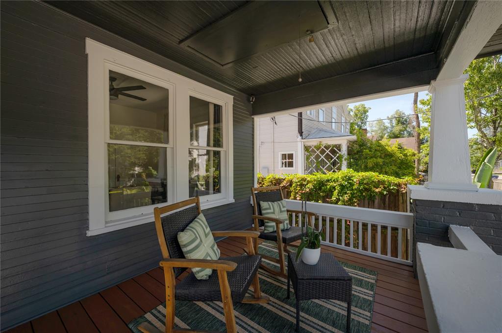 A covered front porch features dark wood siding, two rocking chairs, and a small side table — 2831 N MORGAN STREET, TAMPA, FL