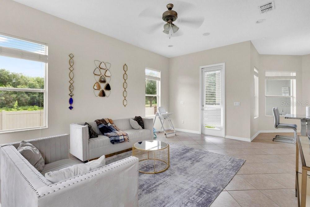 A bright living room features light tile floors, a gray area rug, and white furniture — 912 HIRE CIRCLE, OCOEE, FL