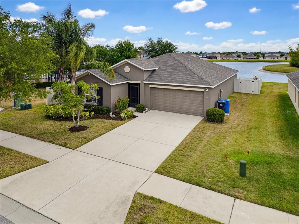 An open-concept living room features a kitchen with brown cabinets and a blue island — 2202 4TH STREET SW, RUSKIN, FL