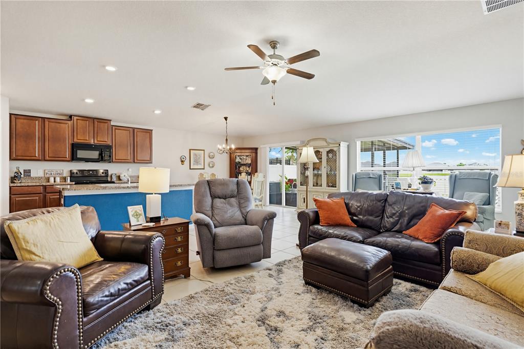 A living room features a leather sofa, a patterned sofa, and a textured area rug — 2202 4TH STREET SW, RUSKIN, FL