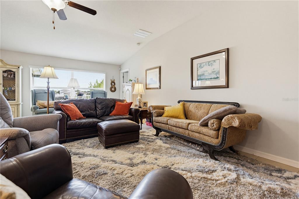 A kitchen features dark wood cabinets, granite countertops, black appliances, and a central island — 2202 4TH STREET SW, RUSKIN, FL
