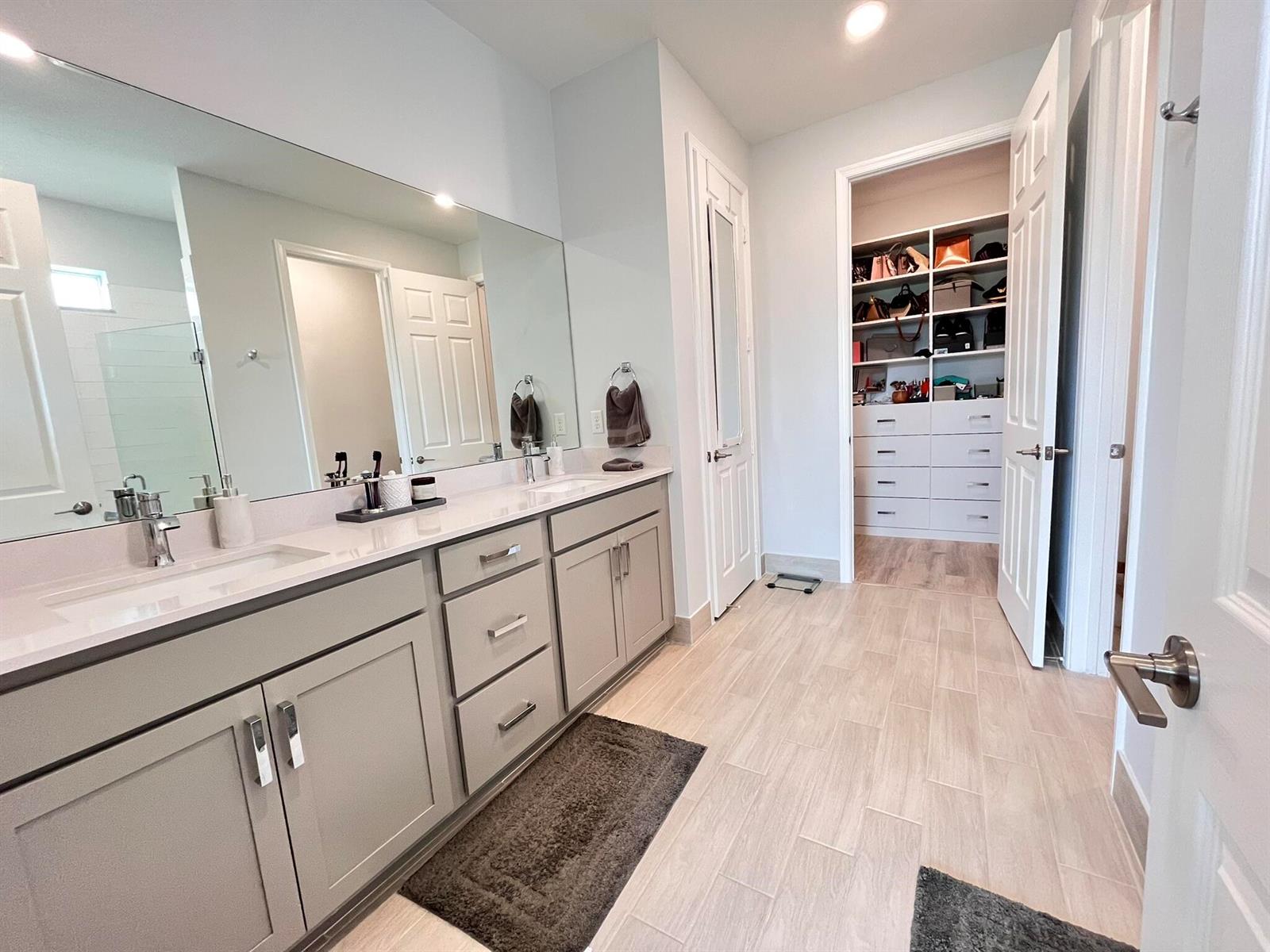 A bathroom features a double vanity with gray cabinets, a large mirror, and an adjacent closet — 1272 Wandering Willow Way, Loxahatchee FL 33470, LOXAHATCHEE, FL