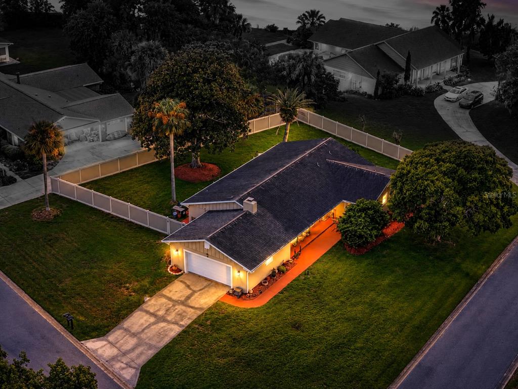 An aerial view of a single-story house with a garage, driveway, and fenced backyard — 20 TWIN RIVER DRIVE, ORMOND BEACH, FL