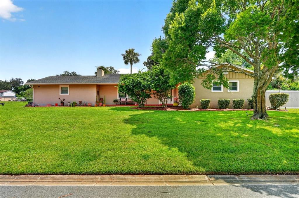 A single-story house with a large lawn, mature trees, and a tan exterior — 20 TWIN RIVER DRIVE, ORMOND BEACH, FL