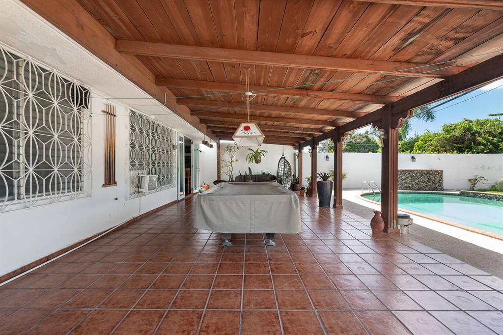 A covered patio with a pool table, tile flooring, and a view of a swimming pool — Urb. Torrimar PASEO DE LA ALHAMBRA UNIT 1-16, GUAYNABO, PR