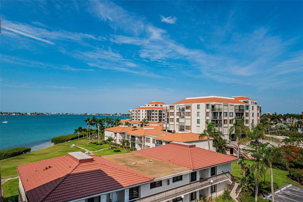 An elevated view of a waterfront apartment complex with red-tiled roofs and palm trees — 6361 BAHIA DEL MAR BOULEVARD UNIT 503, ST PETERSBURG, FL