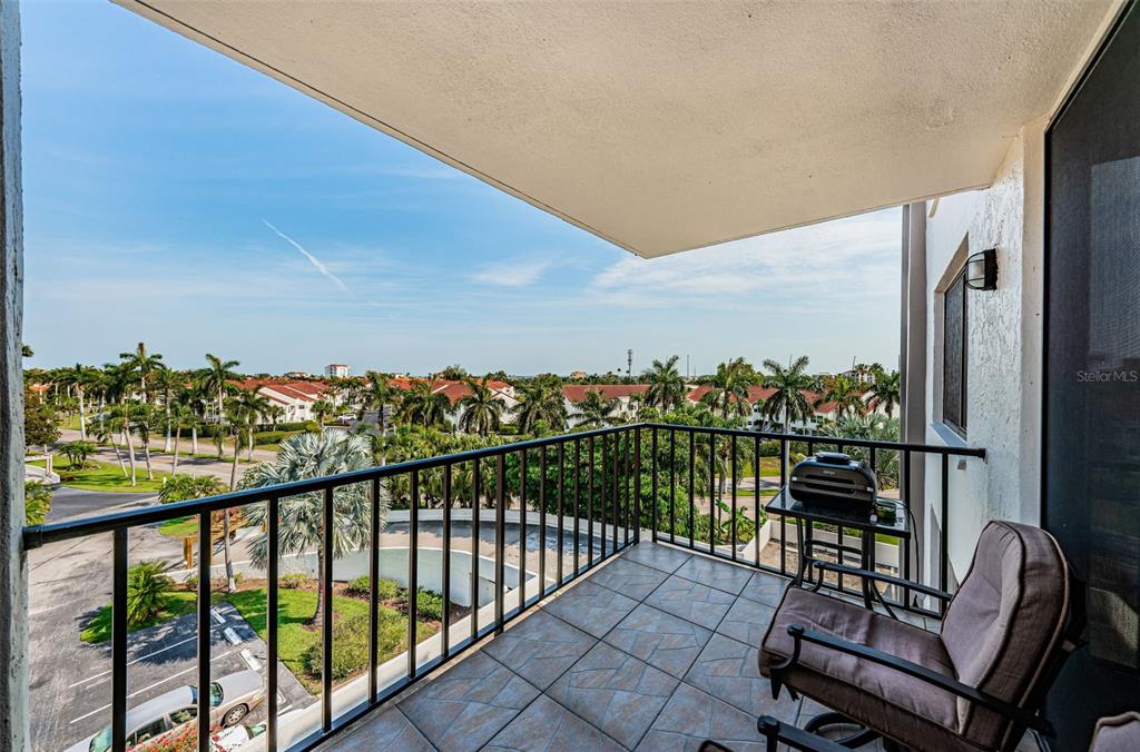 A tiled balcony features a black metal railing, a chair, and a small table with equipment — 6361 BAHIA DEL MAR BOULEVARD UNIT 503, ST PETERSBURG, FL