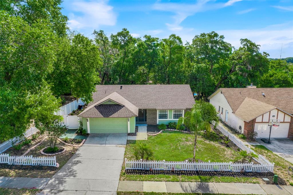 An aerial view of a single-story house with a green garage and a white fence — 5933 GROVELINE DRIVE, ORLANDO, FL