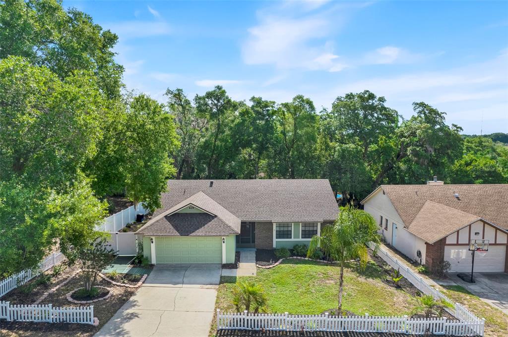 An aerial view of a single-story house with a green garage and white picket fence — 5933 GROVELINE DRIVE, ORLANDO, FL