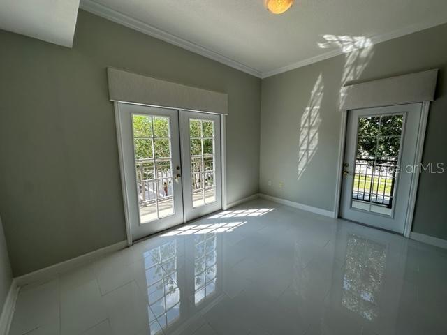 A room with white tile floors, light gray walls, and two sets of glass doors — 917 WATERSIDE LANE UNIT 203, CELEBRATION, FL