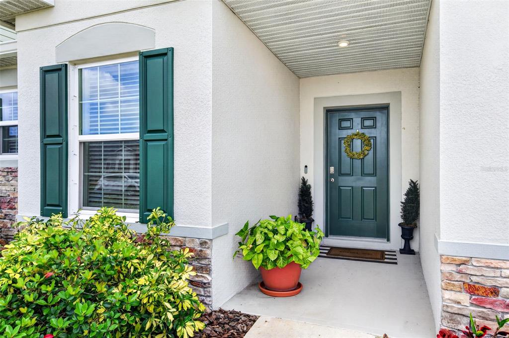 A front entryway features a dark green door with a wreath and a potted plant — 2530 ROYGARIS STREET NW, PALM BAY, FL