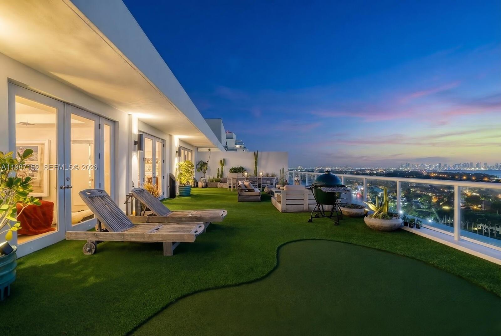 A rooftop terrace features artificial turf, lounge chairs, a grill, and panoramic city views — 5600 Collins Ave # D, Miami Beach FL 33140, MIAMI BEACH, FL